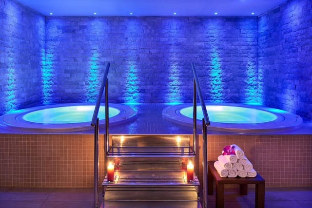 Due vasche idromassaggio rotonde in una spa illuminata di blu